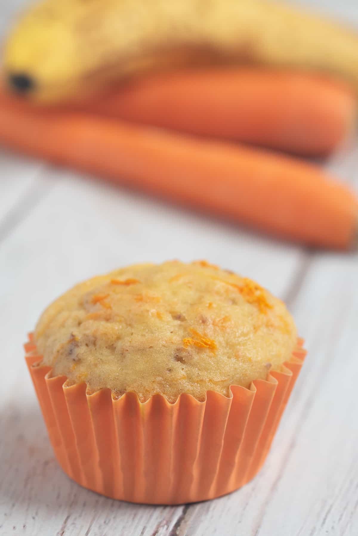 one banana carrot muffin in orange liner. 