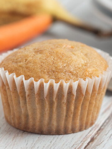 banana carrot muffin with carrot and banana behind.