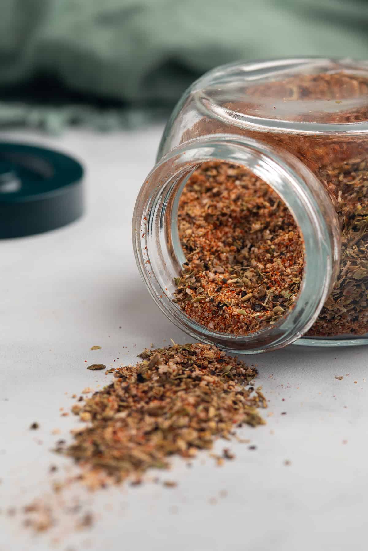 blackened seasoning spilling out of jar onto counter.