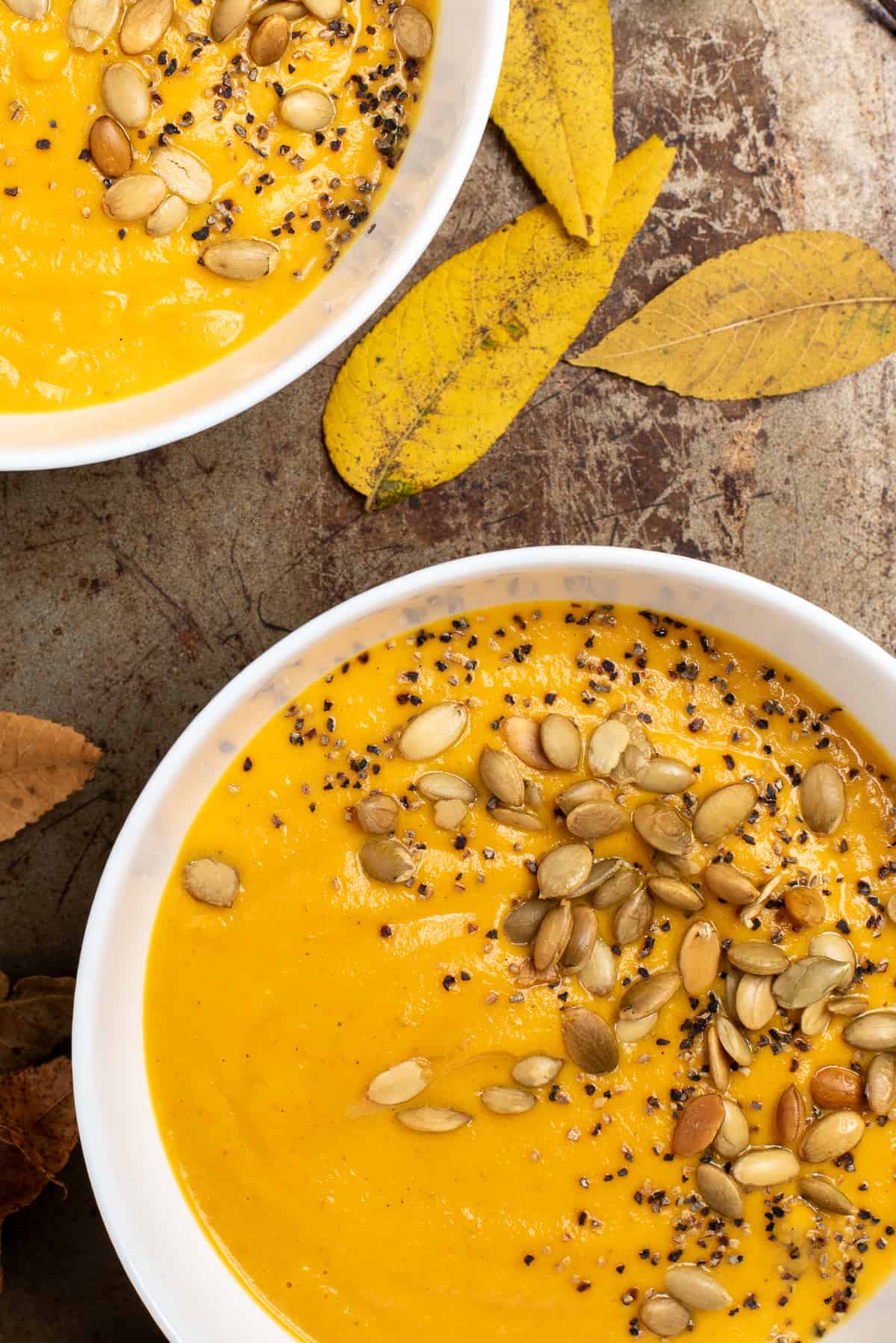 fall leaves with bowls of carrot soup. 