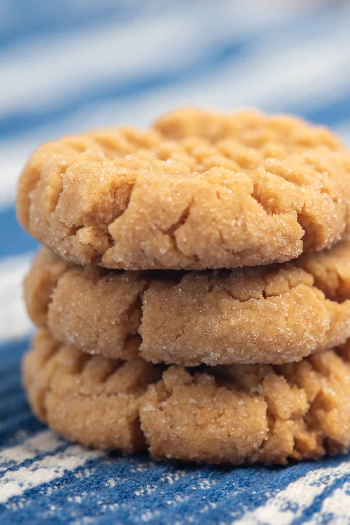 three stacked peanut butter cookies on a blue and white background
