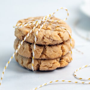 chewy peanut butter cookies tied up with white and red string on a white background