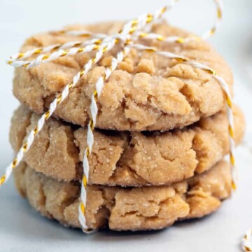 chewy peanut butter cookies tied up with white and red string on a white background