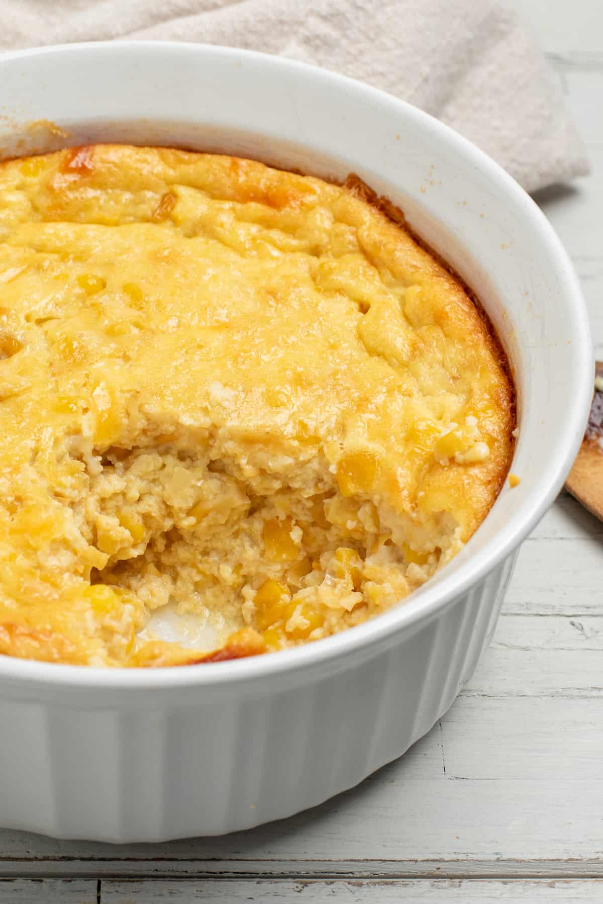 corn casserole with a serving out of dish. 