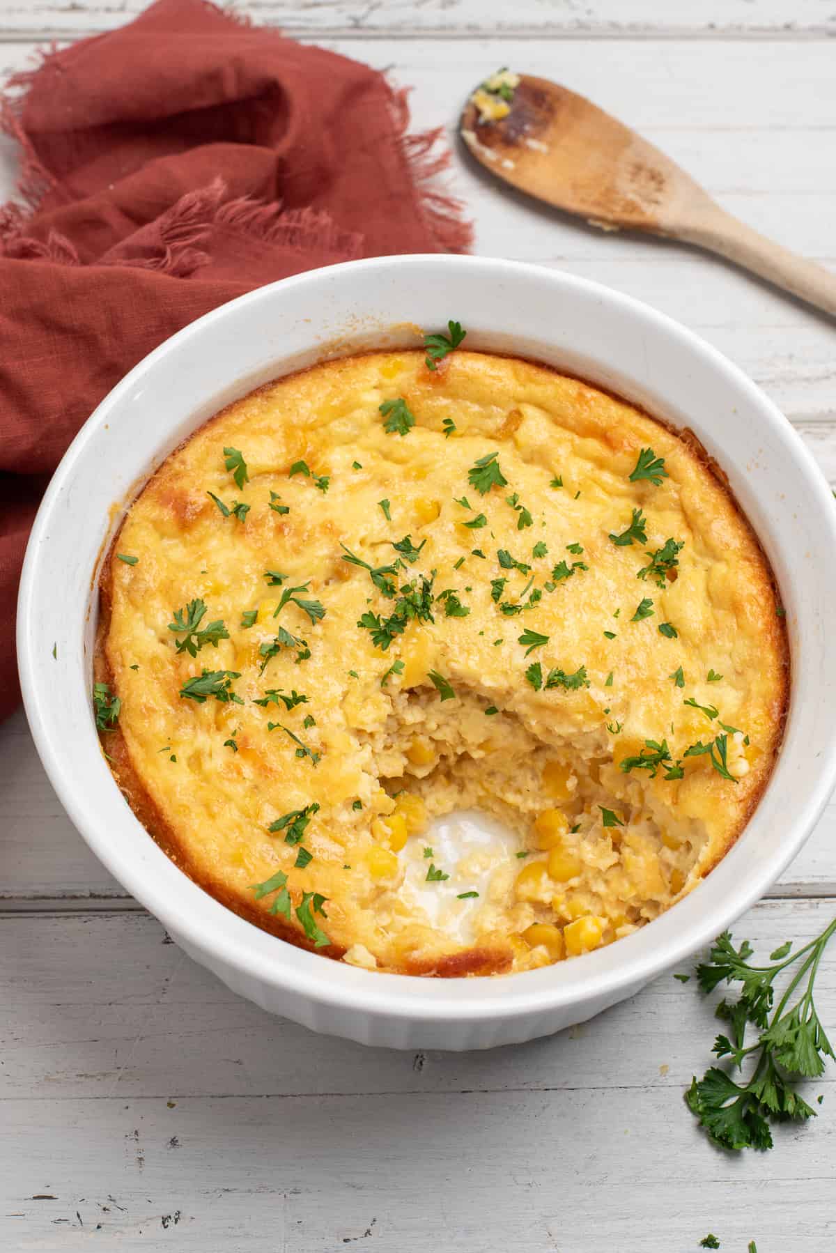 corn casserole with cloth and spoon.