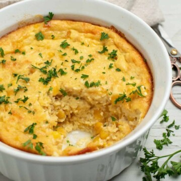 corn souffle casserole with parsley garnish.