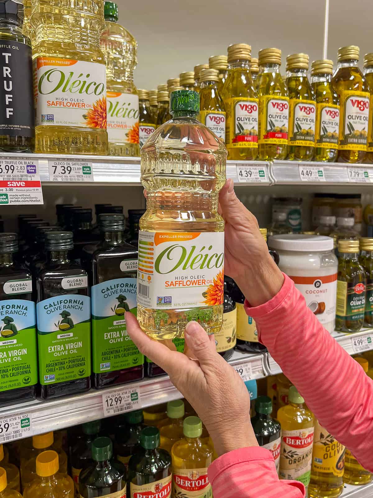 holding a bottle of Oléico safflower oil in the grocery store