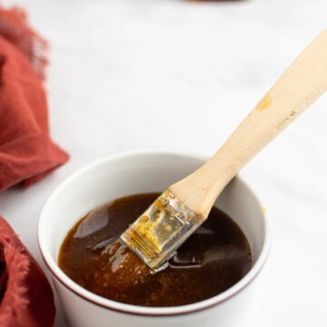 maple bourbon glaze in a white dish with a brush.