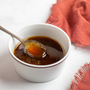 maple bourbon glaze in a white dish with a spoon.