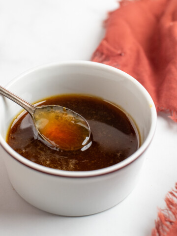 maple bourbon glaze in a white dish with a spoon.