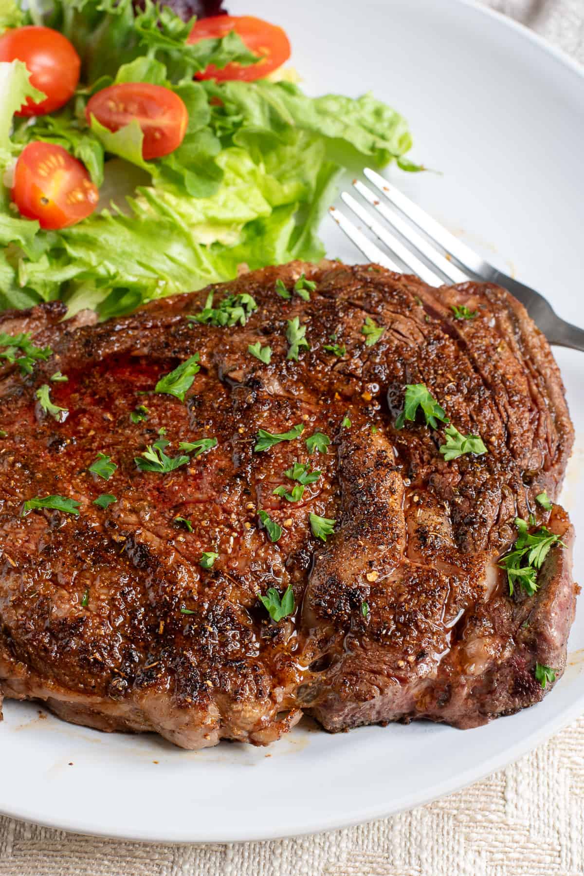 blackened ribeye steak with salad.