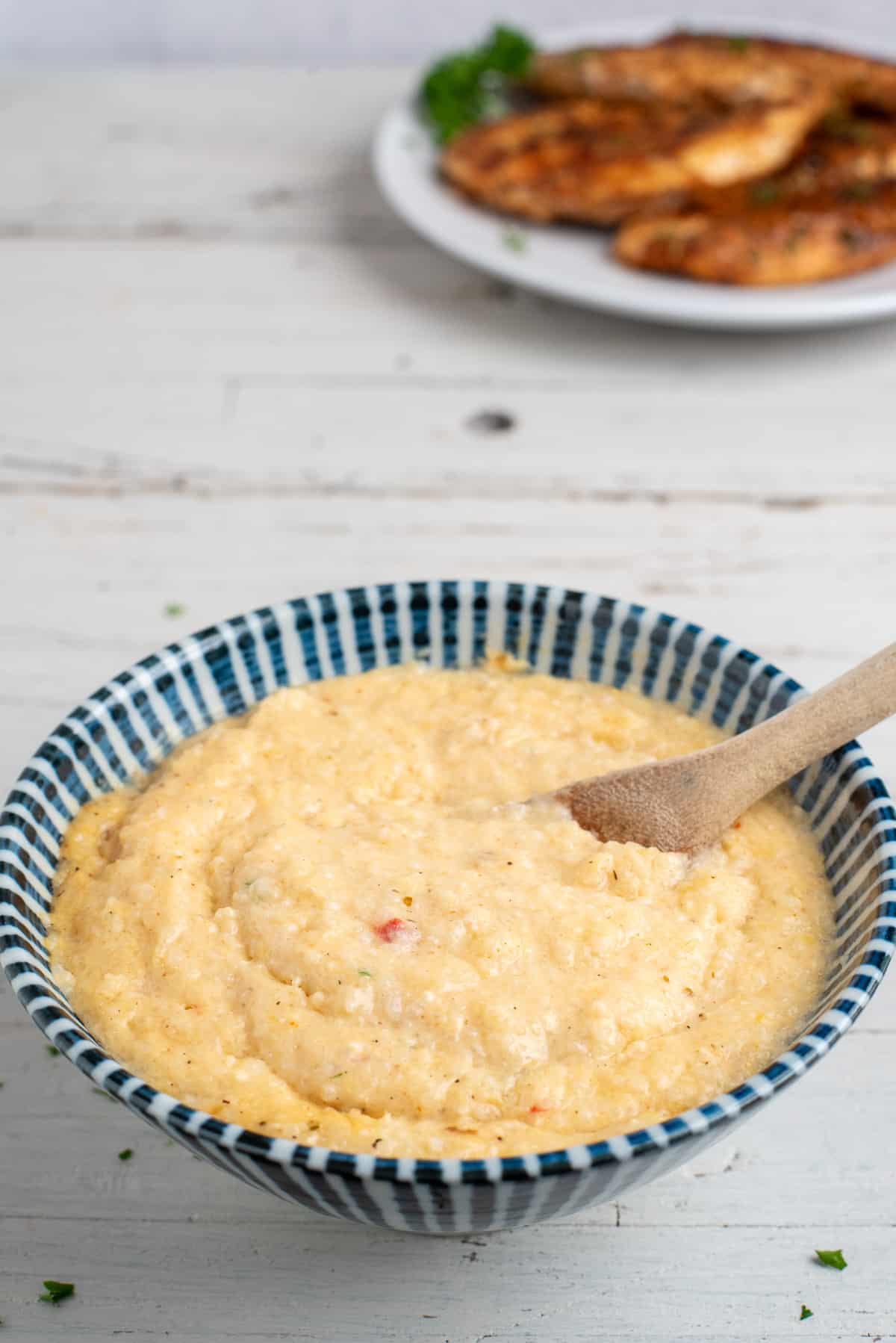 striped bowl with pimento cheese grits and spoon. 