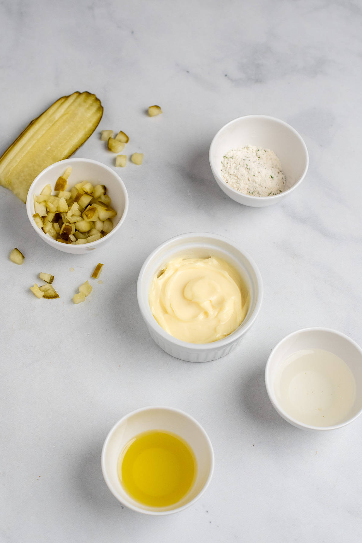 ingredients needed to make dill ranch divided in small white bowls