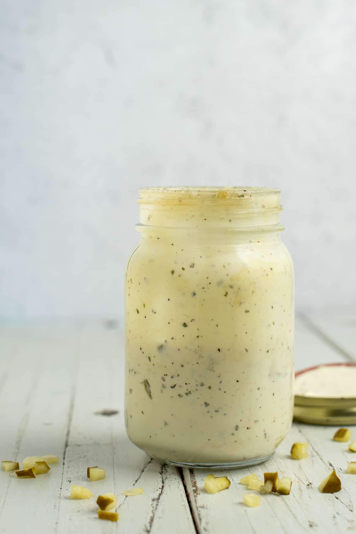 dill pickle ranch dressing in a mason jar with a white background