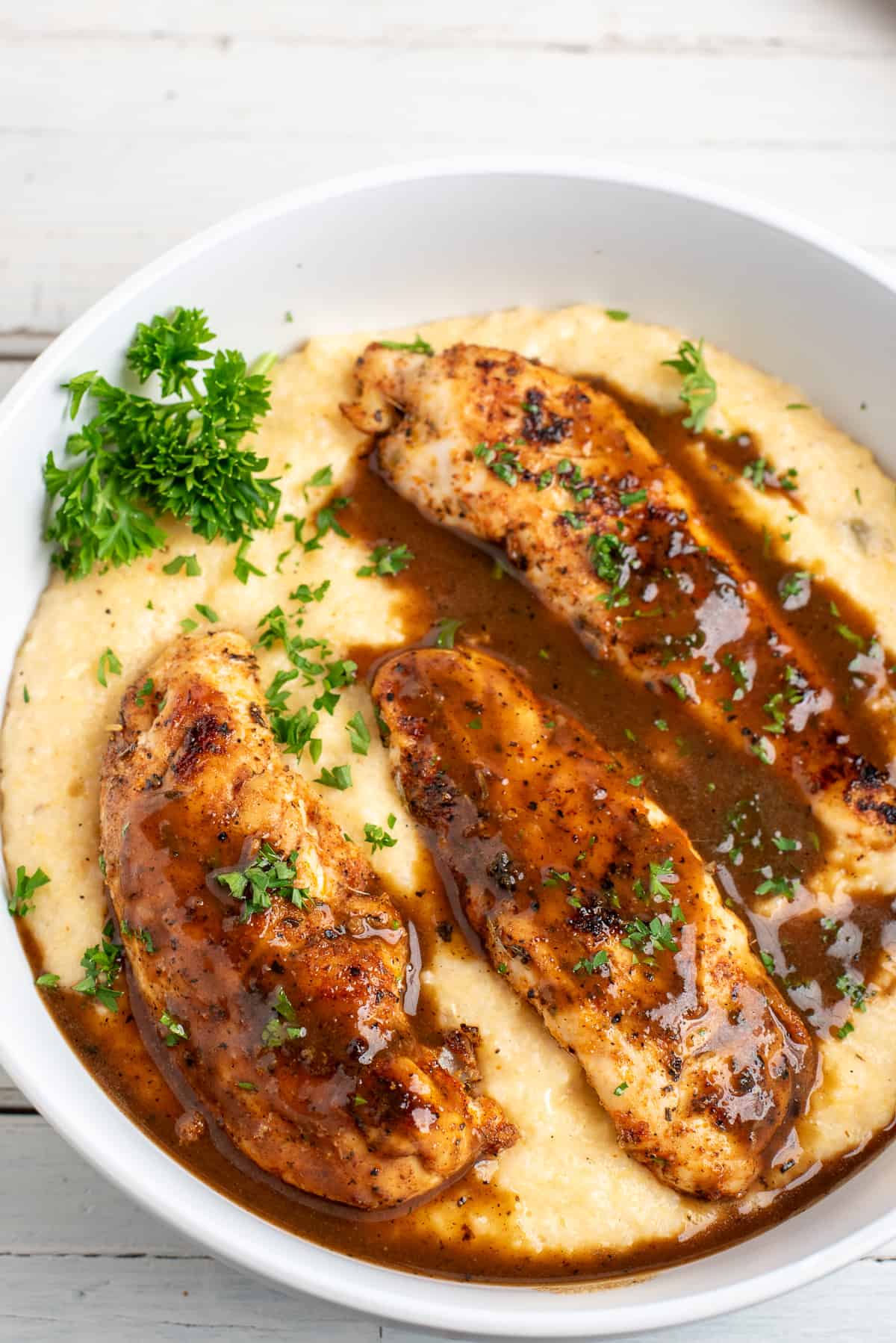 spicy chicken tenders over grits with pan sauce.