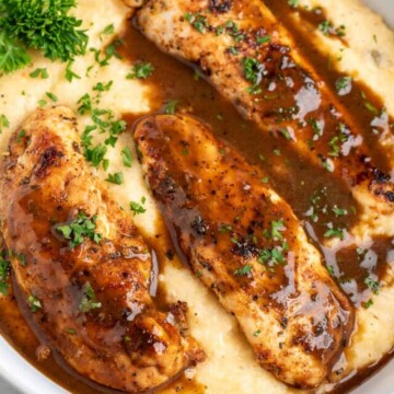 chicken and grits made with pimento cheese grits in white bowl.