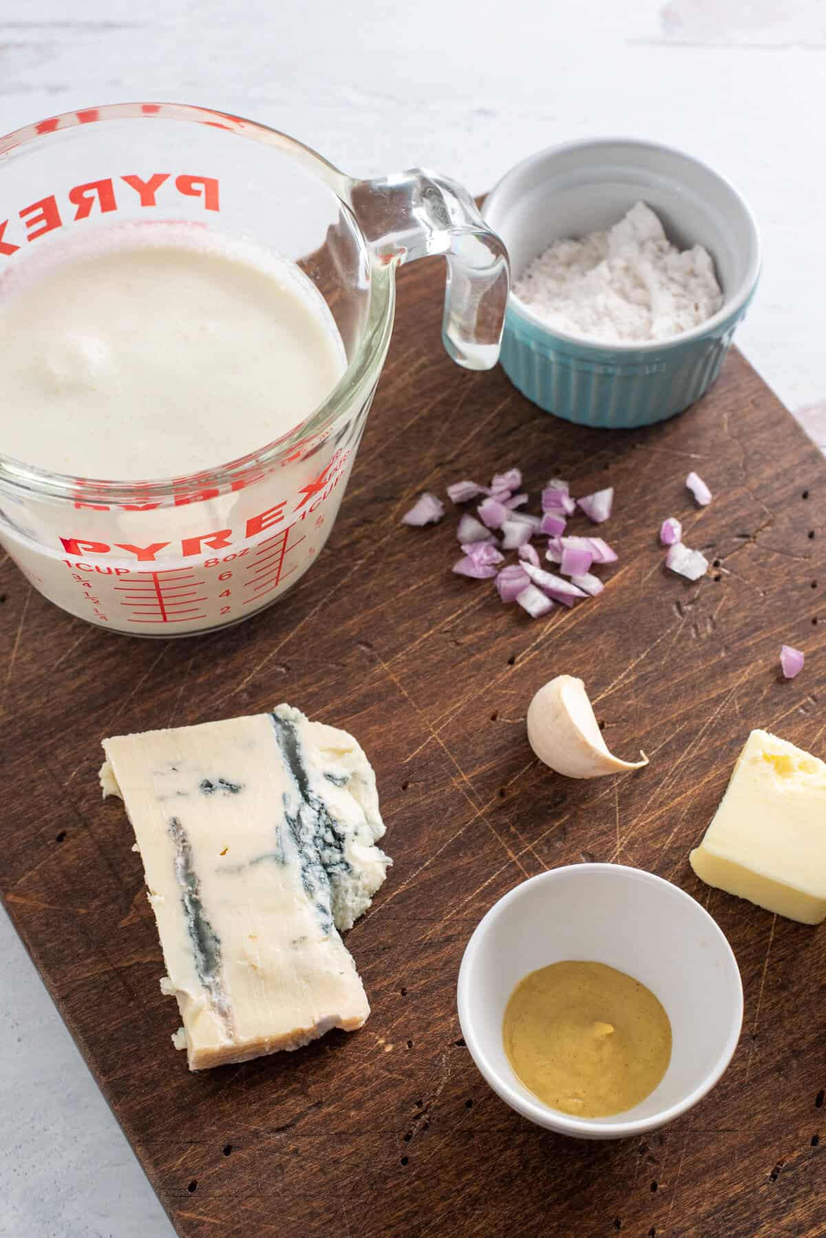 ingredients needed for gorgonzola cream sauce on a cutting board