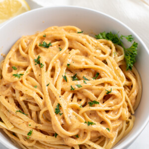 spicy cajun pasta in a white bowl sprinkled with parsley
