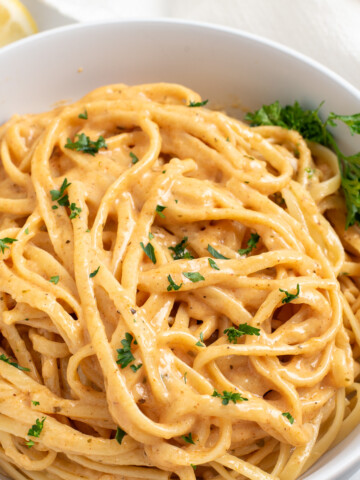 spicy cajun pasta in a white bowl sprinkled with parsley