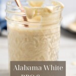 Alabama White Sauce in a glass jar with recipe title in text overlay.