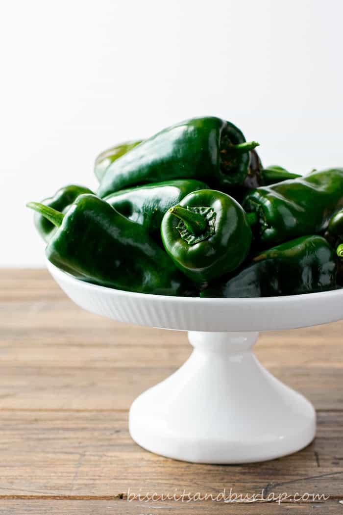 Poblano peppers on a white cake stand.