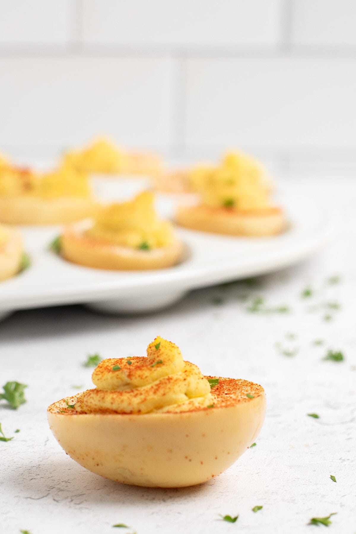 close up of a smoked deviled egg with more behind.