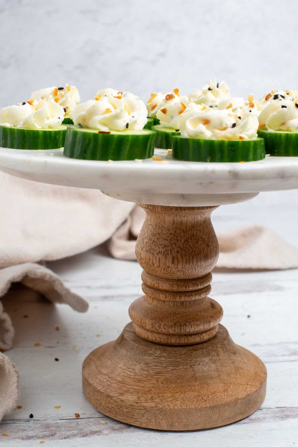 cream cheese cucumber bites on stand.