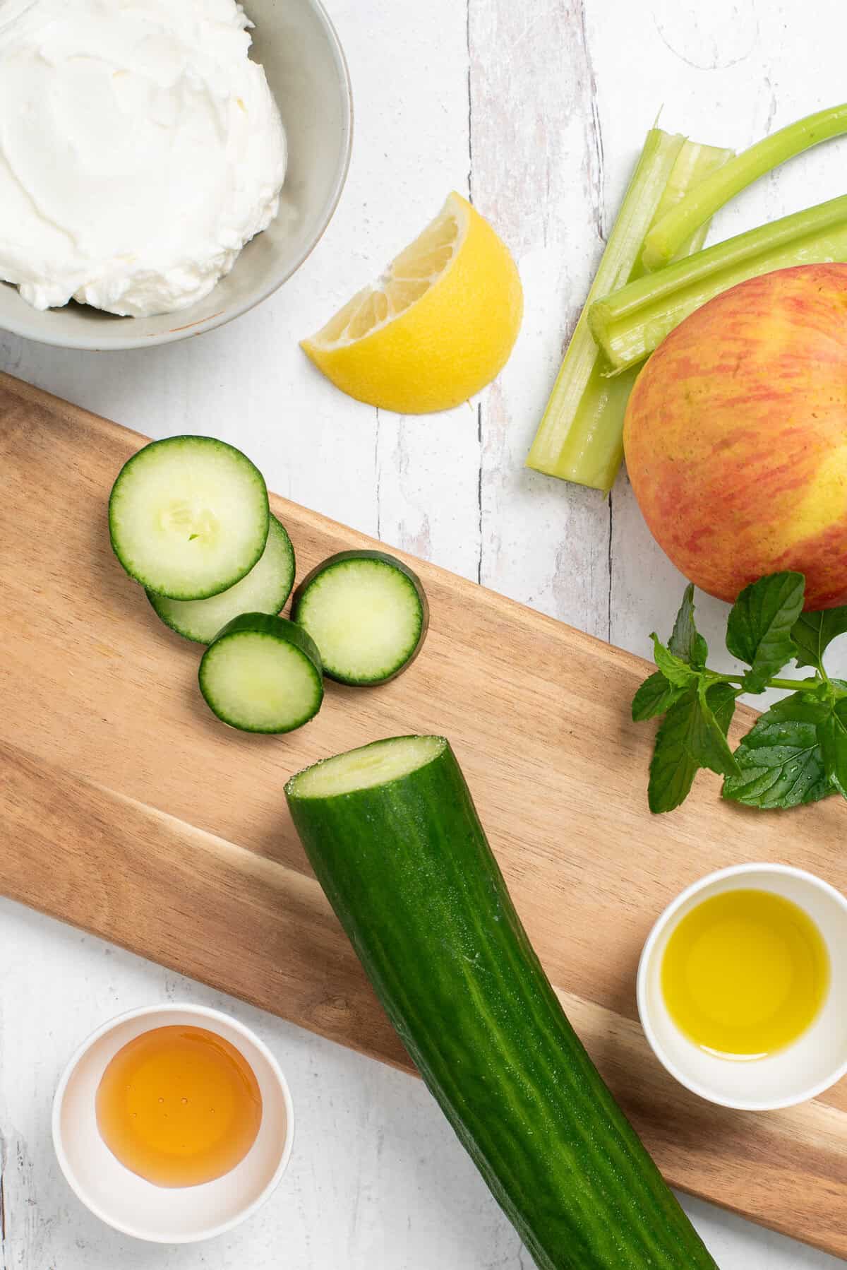 Ingredients needed for cucumber apple salad on a cutting board