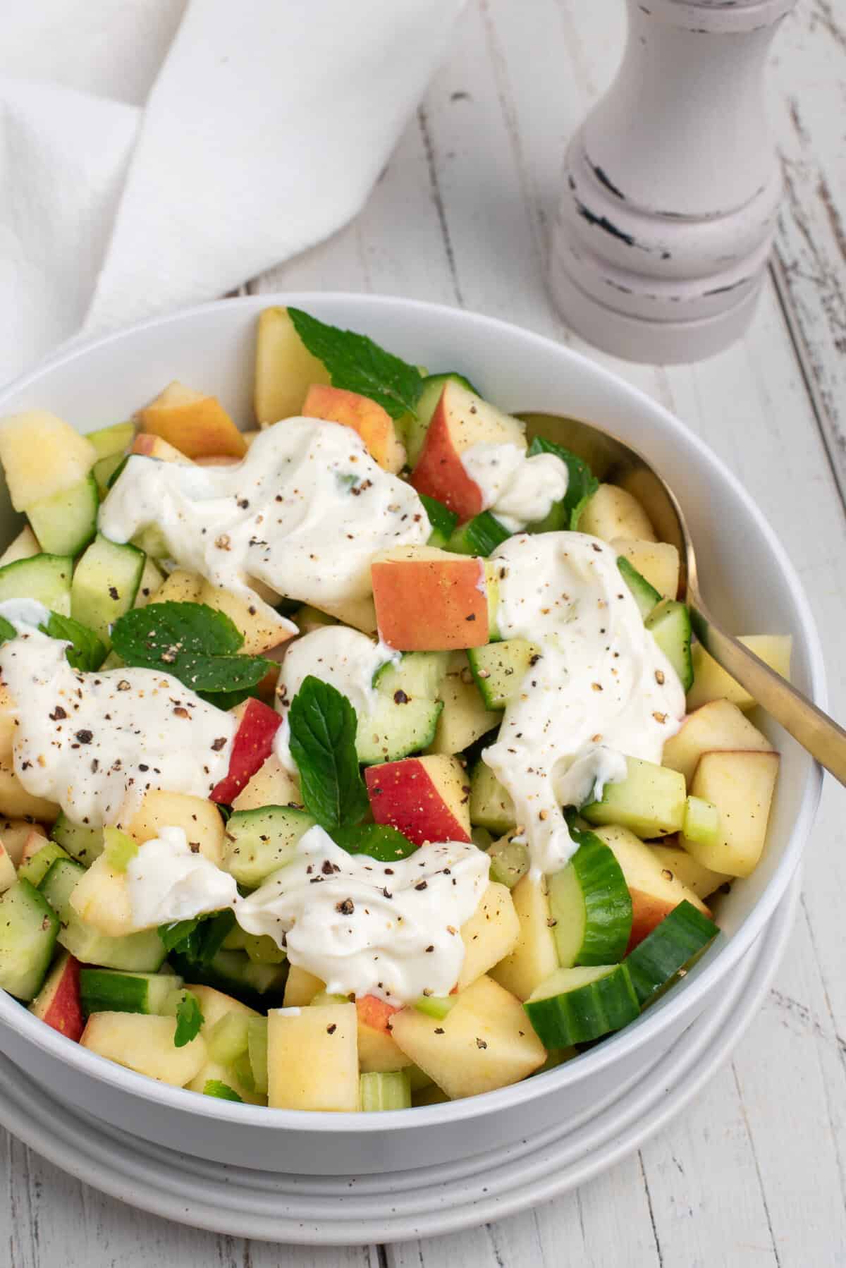 cucumber apple salad topped with yogurt dressing
