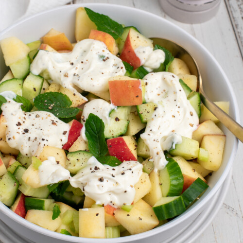 cucumber apple salad topped with yogurt dressing