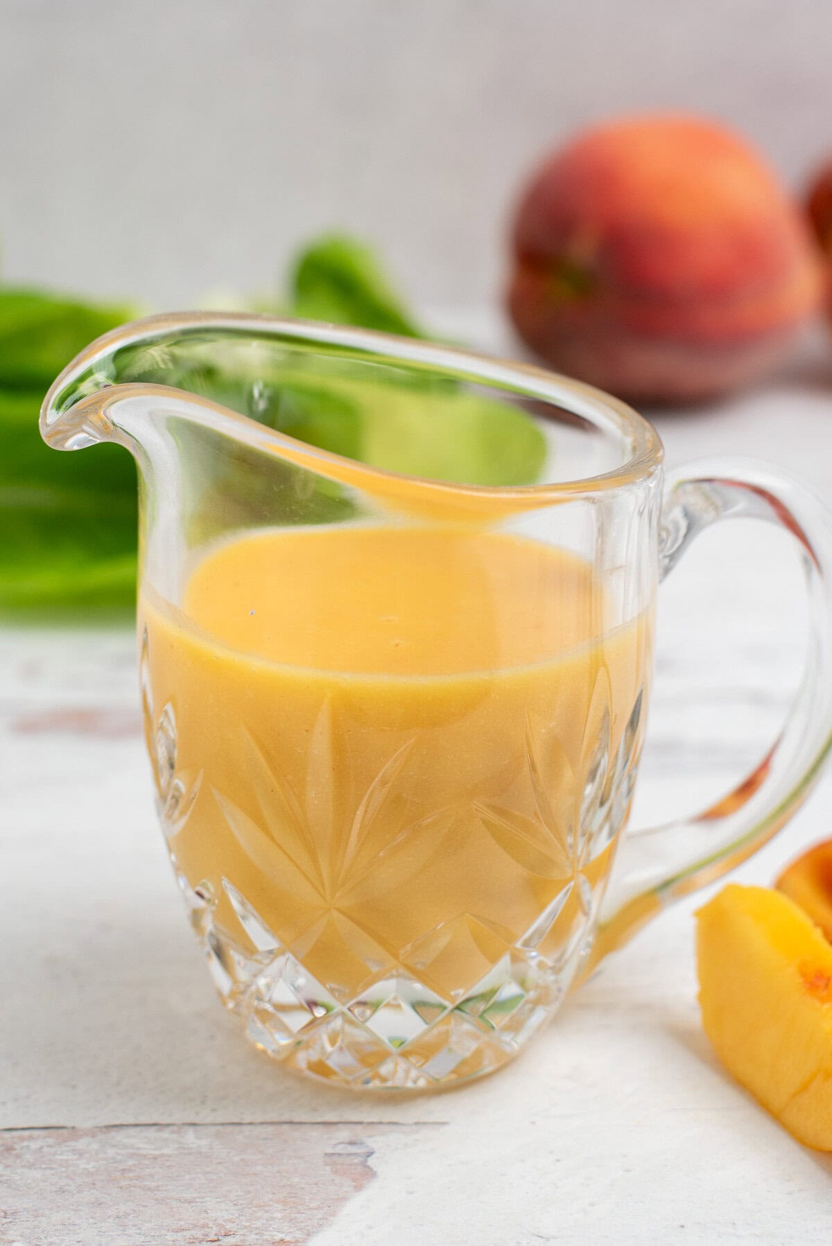 peach salad dressing in a glass pitcher