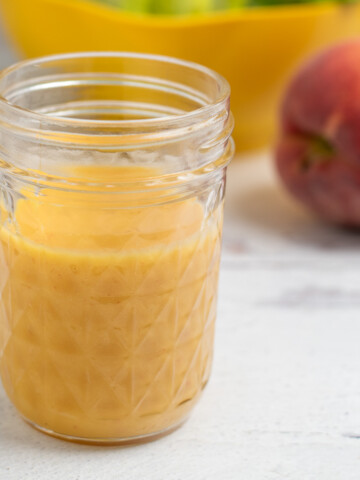 peach salad dressing in a glass mason jar