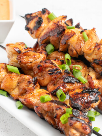 grilled bang bang chicken skewers on a platter