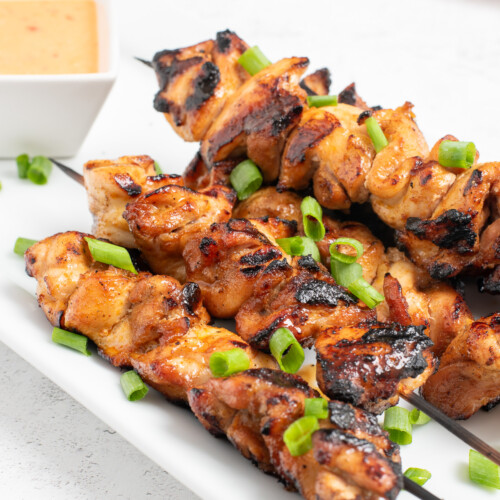 grilled bang bang chicken skewers on a platter