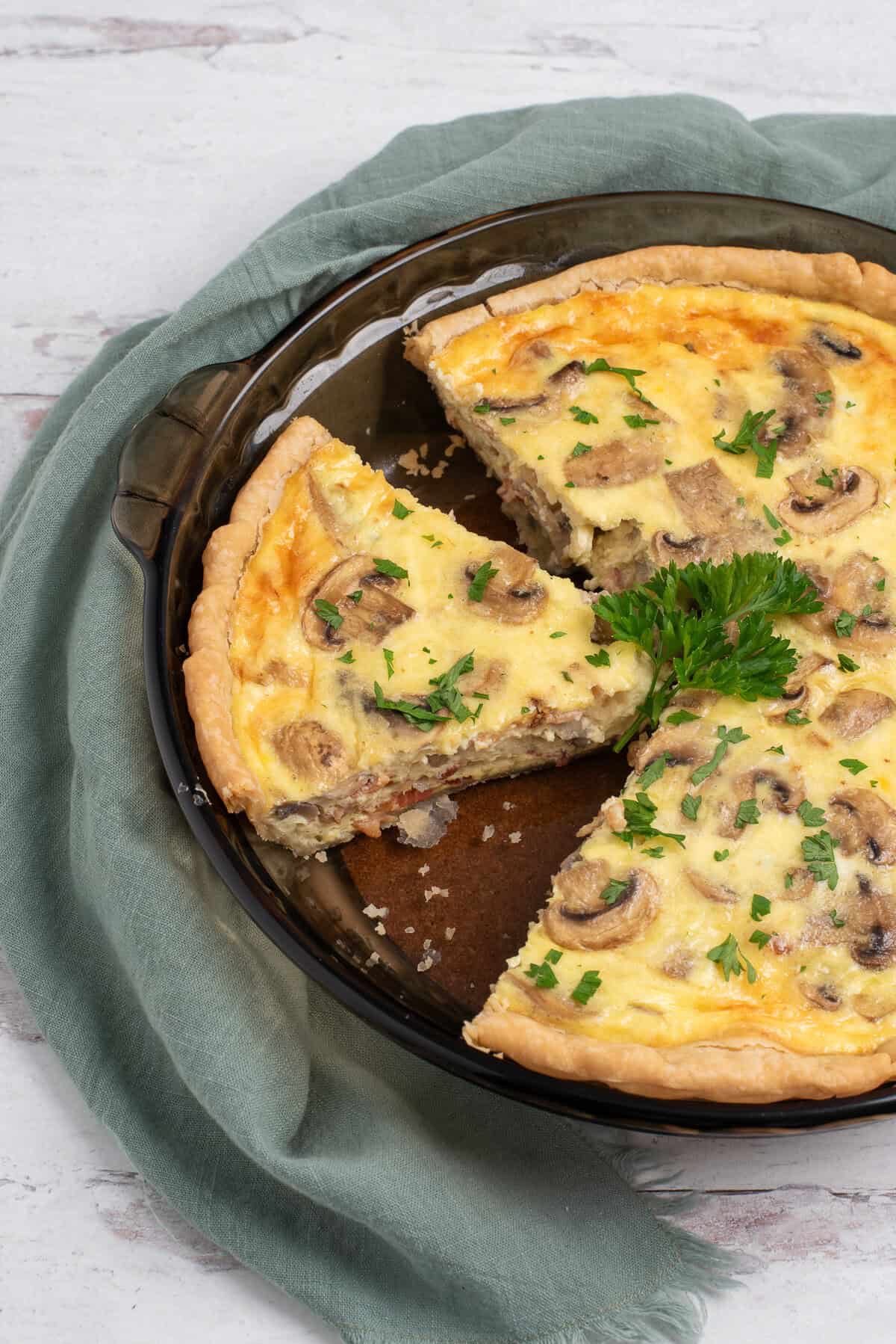 bacon and mushroom quiche with caramelized onions, 1 slice cut out.