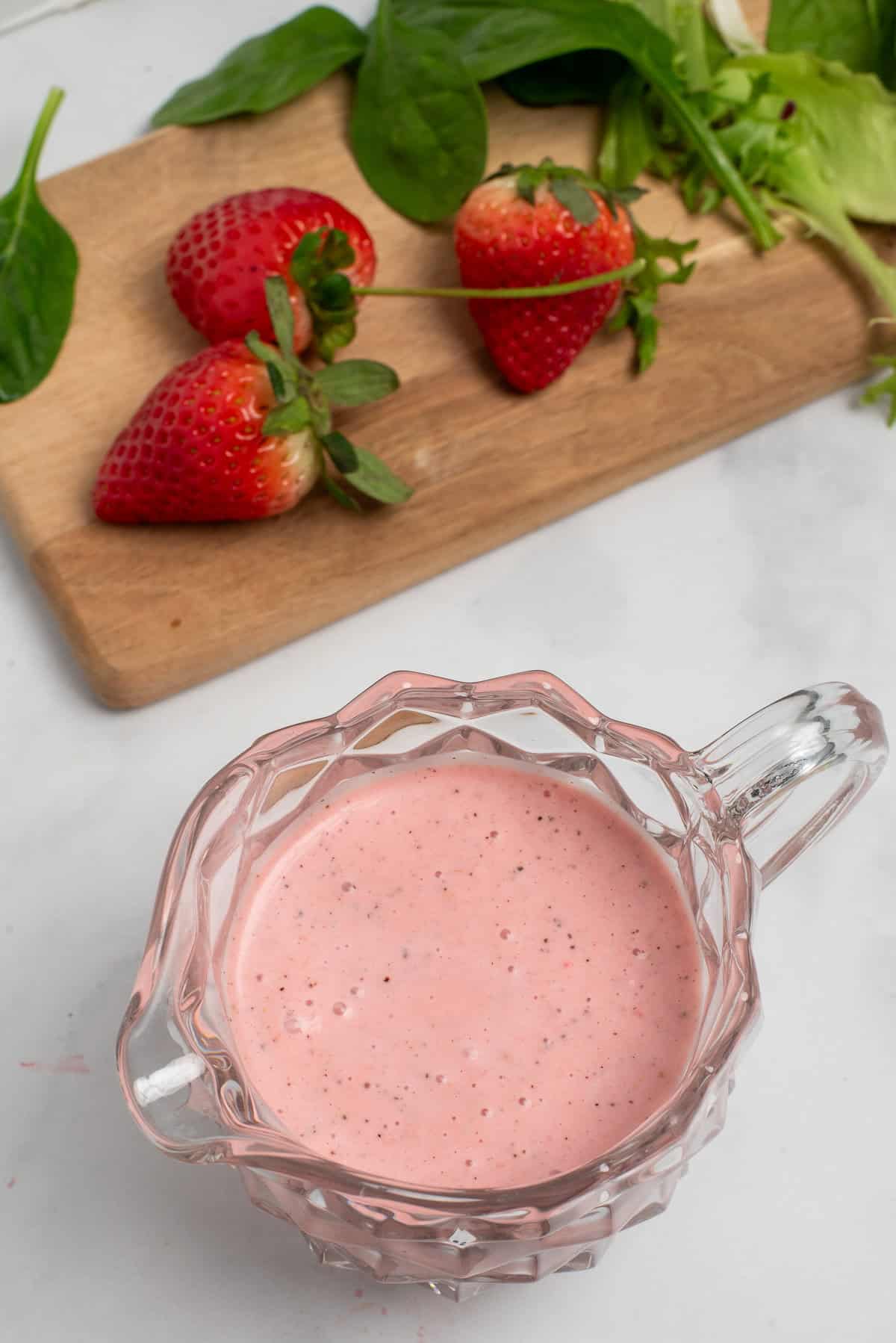 overhead shot of strawberry salad dressing with strawberries on board.