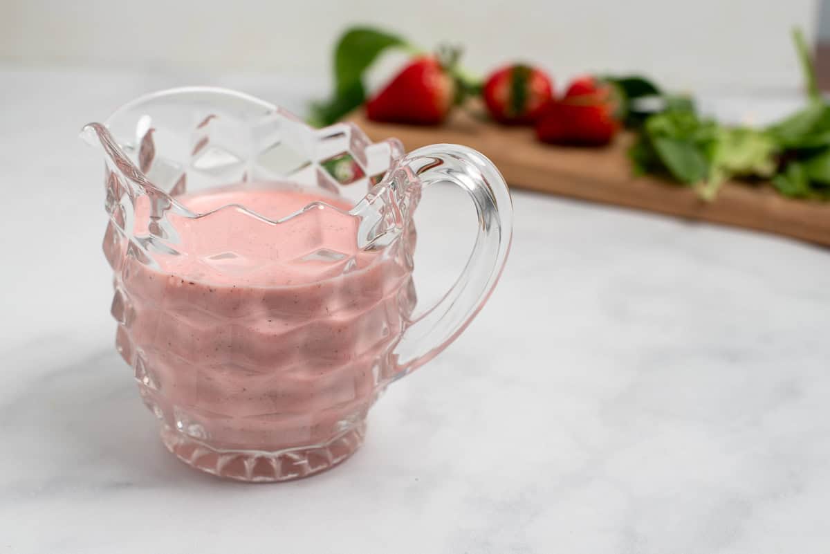 Facebook image of strawberry salad dressing with strawberries behind.