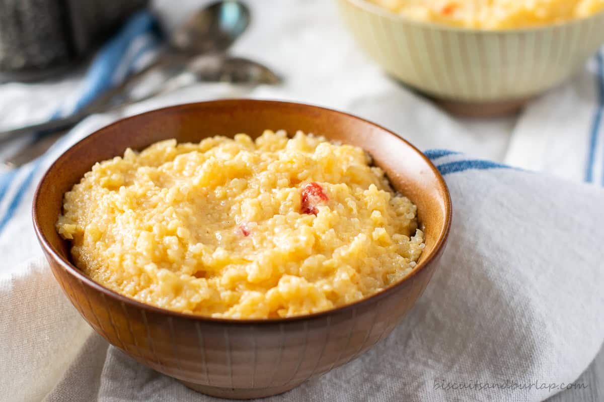 Pimento cheese grits in a brown bowl.