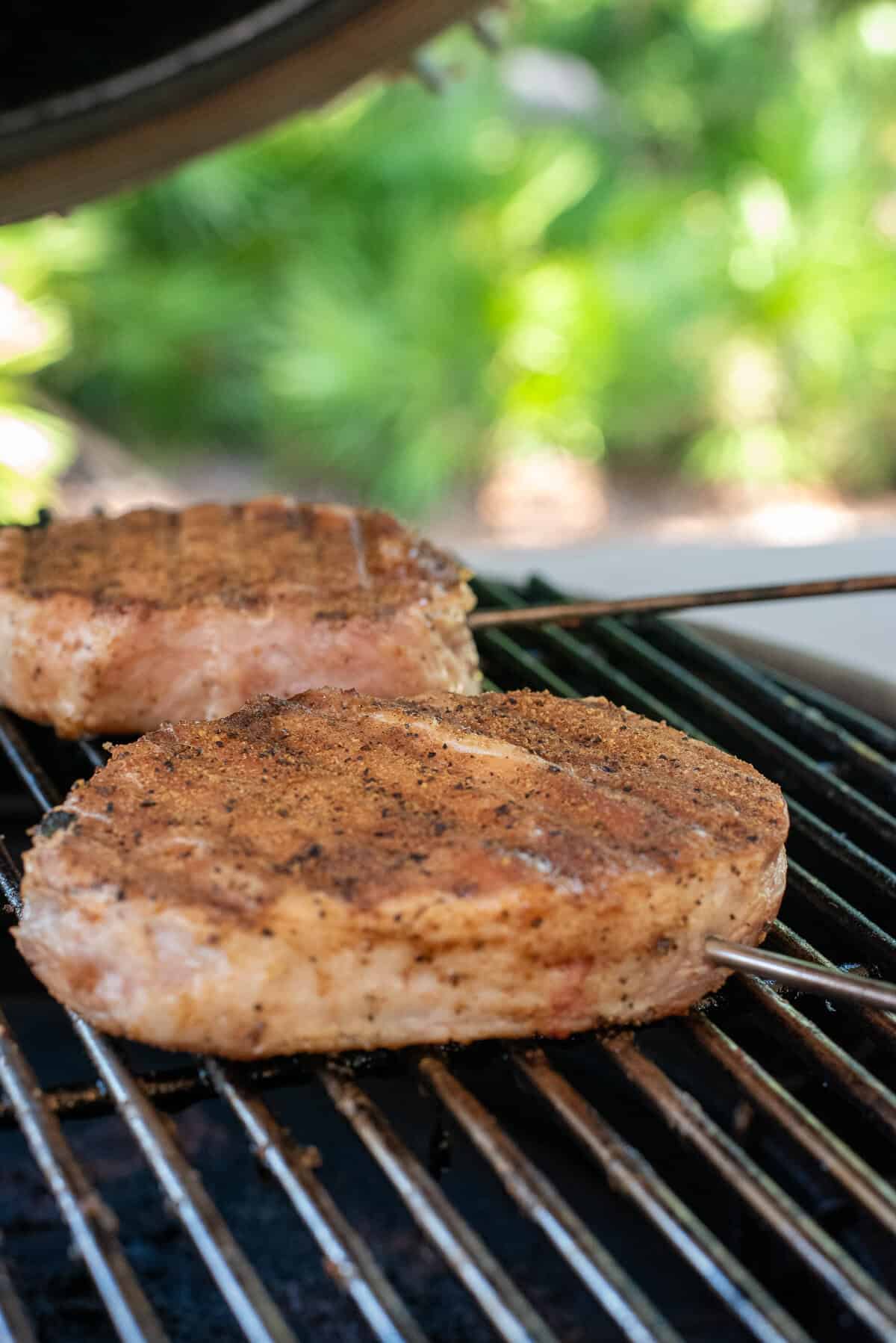 smoked pork chops on smoker with temperature probe.