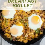 A breakfast skillet topped with fried eggs with the recipe title in a text overlay.