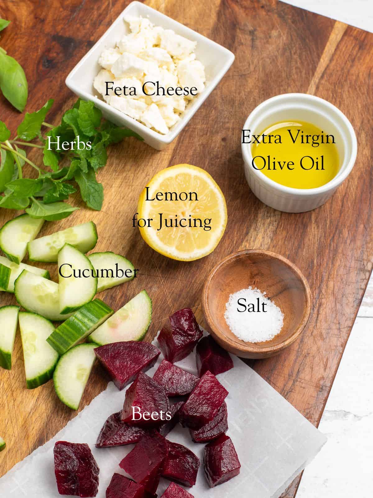 The ingredients needed to make cucumber beet salad on a cutting board.