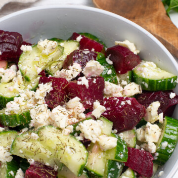 Cucumber and beet salad topped with feta cheese and fresh herbs.
