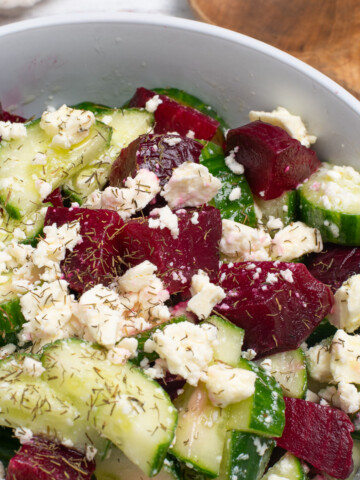 Cucumber and beet salad topped with feta cheese and fresh herbs.