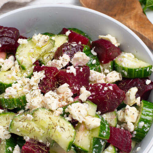 Cucumber and beet salad topped with feta cheese and fresh herbs.