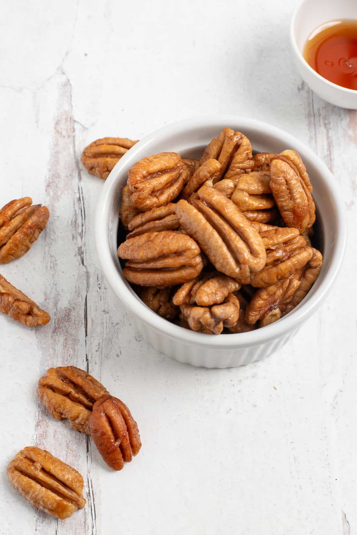 Honey roasted pecans in white bowl.