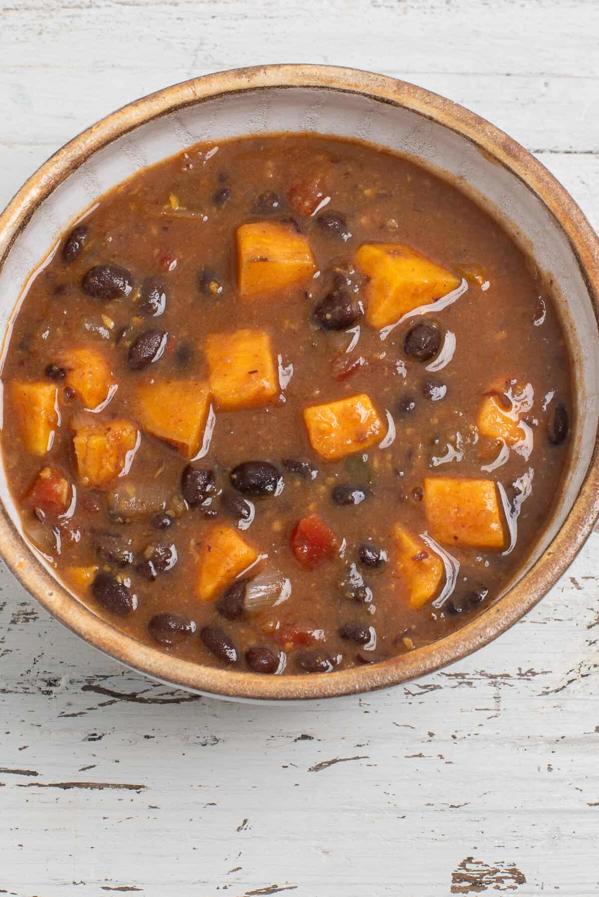 A tan bowl filled with black bean sweet potato soup.